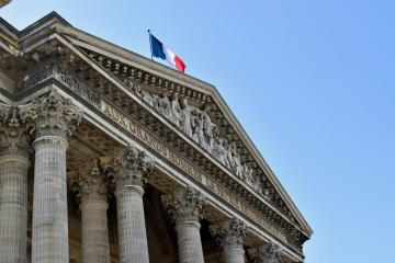 1. The image shows the pediment and columns of a neoclassical building with a French flag flying atop, and inscribed text on the frieze reading "BANQUE DE FRANCE".