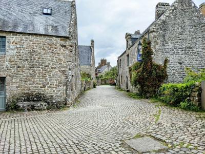 A stone-paved lane flanked by ancient granite buildings leading toward a courtyard.