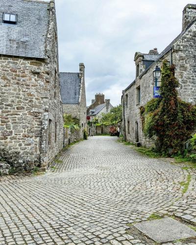 A stone-paved lane flanked by ancient granite buildings leading toward a courtyard.