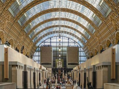 View of the grand central hall with a vaulted glass ceiling and sculptures at the Musée d'Orsay.