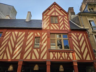 Photographic facade of a red and cream half-timbered Renaissance house in Rennes, France.