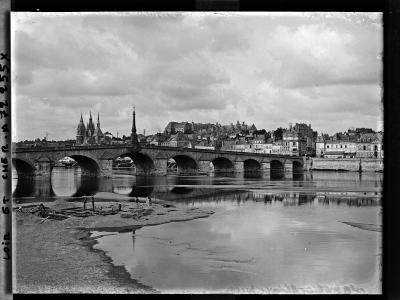 A black and white photograph showing a multi-arched stone bridge spanning a wide river, with a city skyline featuring a large castle on a hill and a cathedral in the background; handwritten text on the left border reads "LOIR ET CHER. A 72 255 X".