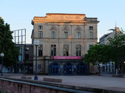 The image shows a large, classical-style stone building with "THEATRE MUNICIPAL" inscribed on its facade and a pink banner reading "le Granit scène nationale" above the entrance.