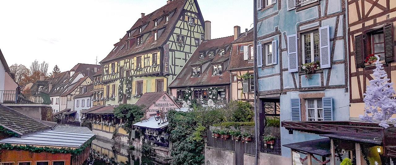 Half-timbered houses decorated for Christmas along the canal in Colmar's Petite Venise quarter