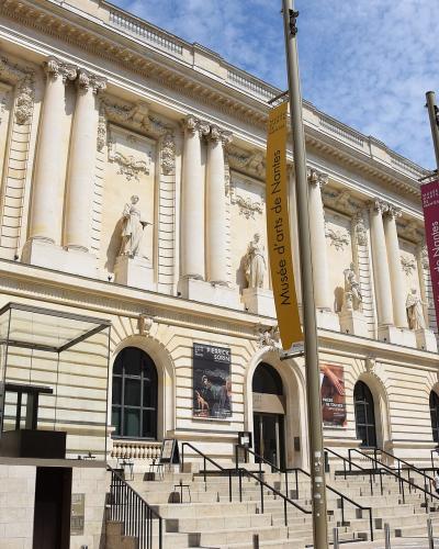 Neoclassical facade of the Musee d'Arts de Nantes with banners over the entrance steps.