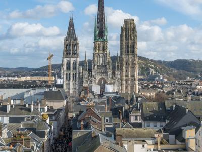 A high-angle view looking down a crowded street lined with historic buildings towards the Rouen Cathedral, with the filename indicating the photo was taken from the Gros Horloge archway.