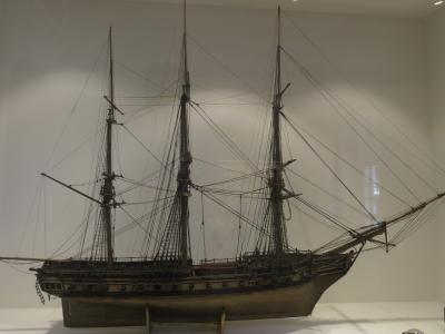Detailed scale model of a three-masted frigate displayed in a museum.