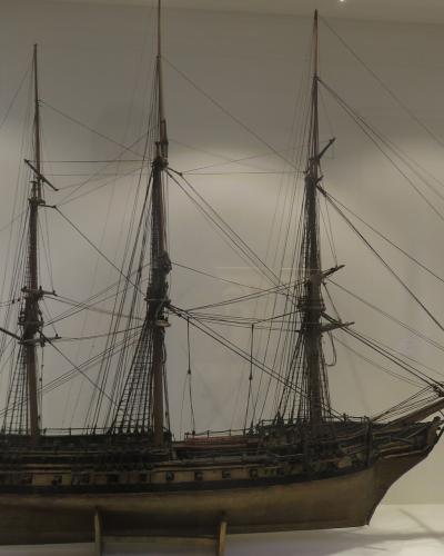 Detailed scale model of a three-masted frigate displayed in a museum.