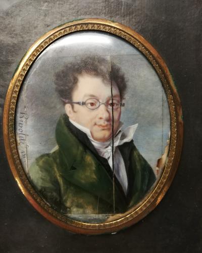 Portrait miniature of a man with glasses in an oval frame.