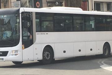 A white MAN Lion's Intercity coach bus driving on a city street, with visible signage including "Ligne 832" on the destination display and a French license plate.