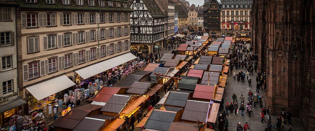 Rows of Christmas market huts on Place de la Cathédrale in Strasbourg, seen from above, beside the cathedral