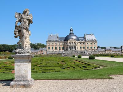 Château de Vaux-le-Vicomte and its formal gardens with a statue in the foreground.