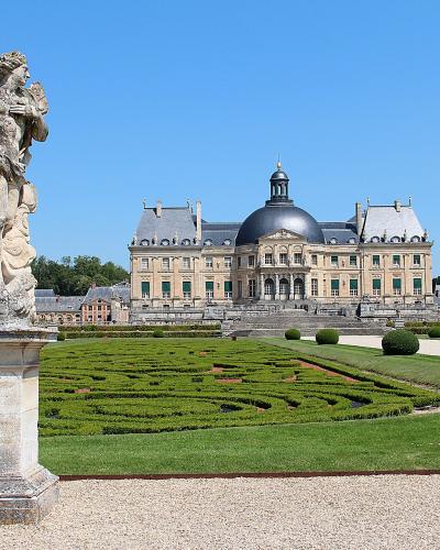 Château de Vaux-le-Vicomte and its formal gardens with a statue in the foreground.