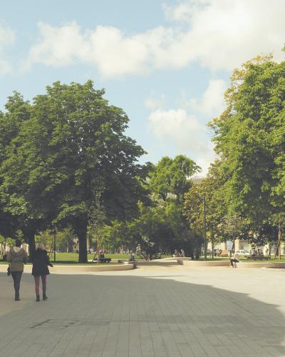 A wide, paved public square or park area with large green trees, people walking, and a building facade on the left under a partly cloudy sky.