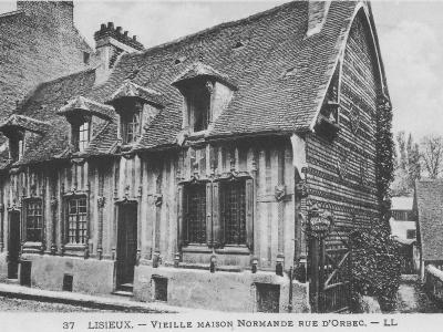 A black and white photograph of a historic half-timbered house with a steep tiled roof and dormer windows, featuring a sign for "CASINO A GAUCHE" on the right side.