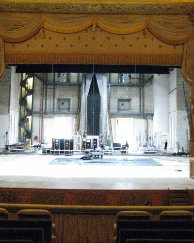 The golden-framed stage and audience seating of the Royal Opera at Versailles during a production setup.