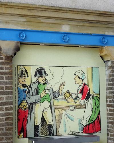 A framed vintage illustration depicting a scene with a soldier and a woman serving coffee, mounted on an exterior wall under a stone and blue metal lintel.