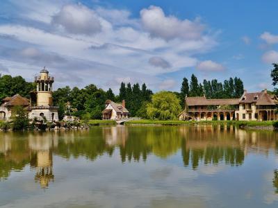 The Queen's Hamlet at Versailles, featuring the tower and buildings across the lake.