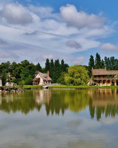 The Queen's Hamlet at Versailles, featuring the tower and buildings across the lake.