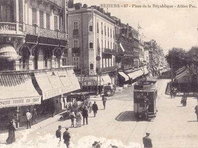 A vintage sepia photograph showing a street scene in Béziers, France, featuring a tram, horse-drawn carriages, pedestrians, and buildings with awnings, with the caption "BEZIERS - 87 - Place de la République - Allées Paul Riquet" at the top.