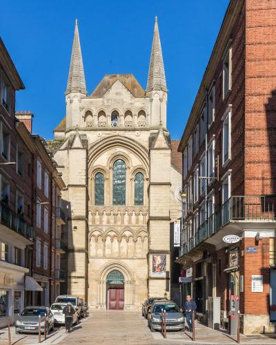 The image shows the south facade of a Gothic cathedral with two prominent spires, arched windows, and a central entrance, situated at the end of a narrow street lined with brick buildings; visible signage includes "RUE SAINT-CRÉPIN" and "ADREA," i