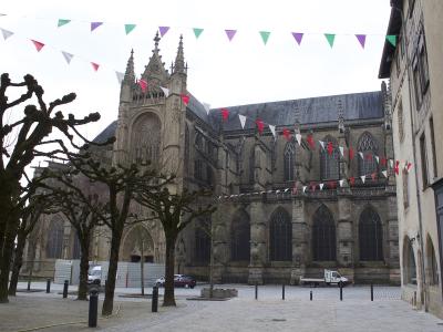 A view of the Gothic facade of Saint-Étienne Cathedral in Limoges with festive bunting overhead.