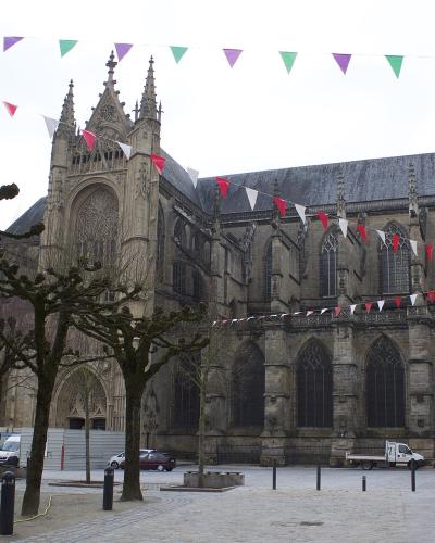 A view of the Gothic facade of Saint-Étienne Cathedral in Limoges with festive bunting overhead.