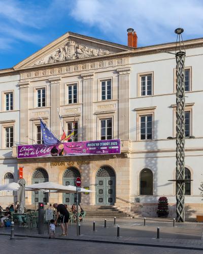 A large, classical-style white building with a pediment, columns, and a banner reading "Chalon au fil de l'été" and "Hôtel de Ville" above the entrance.
