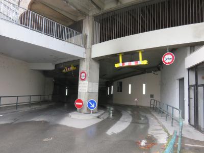 The image shows a concrete vehicle entrance ramp with height restriction signs (3.2m), traffic signs, and a sign reading "ENTRÉE RÉSERVÉE AUX LIVRAISONS DE LA HALLE" (Entrance reserved for deliveries of the market).