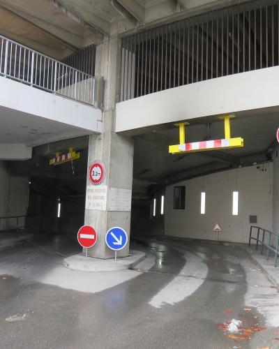 The image shows a concrete vehicle entrance ramp with height restriction signs (3.2m), traffic signs, and a sign reading "ENTRÉE RÉSERVÉE AUX LIVRAISONS DE LA HALLE" (Entrance reserved for deliveries of the market).