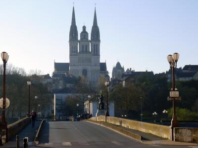 The image shows a stone bridge with a road and pedestrian walkway, featuring a signpost on the right that reads "PONT DE VERDUN" and "La Maine," with the Cathédrale Saint-Maurice d'Angers visible in the background.