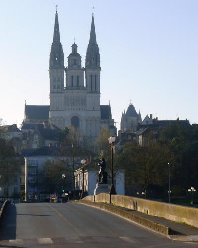 The image shows a stone bridge with a road and pedestrian walkway, featuring a signpost on the right that reads "PONT DE VERDUN" and "La Maine," with the Cathédrale Saint-Maurice d'Angers visible in the background.