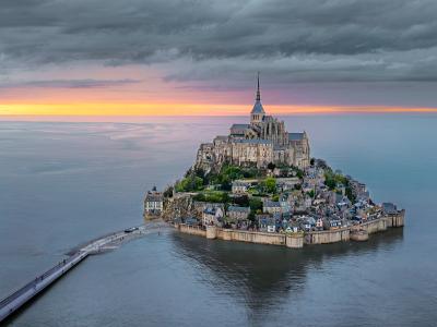 Mont-Saint-Michel and its causeway rising from the bay at sunset, Normandy