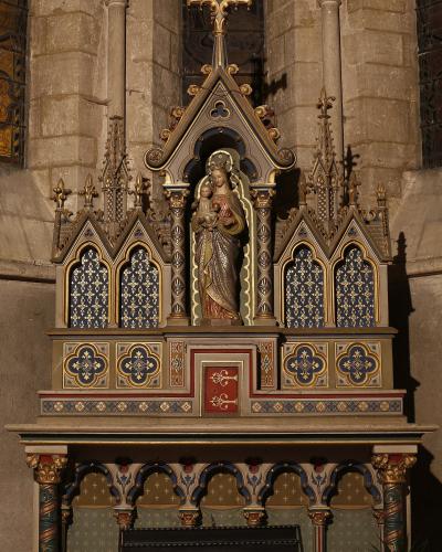 Ornate Gothic-style altar with a central statue of the Madonna and Child in Auxerre's cathedral.
