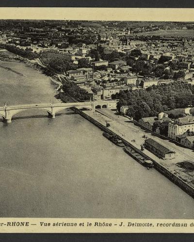 A vintage postcard showing a suspension bridge over a river with a cityscape in the background, featuring printed text "VALENCE-SUR-RHONE." and handwritten French correspondence.