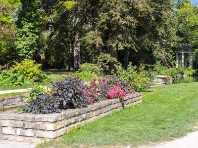 Flower bed by canal with classical pavilion in the background.
