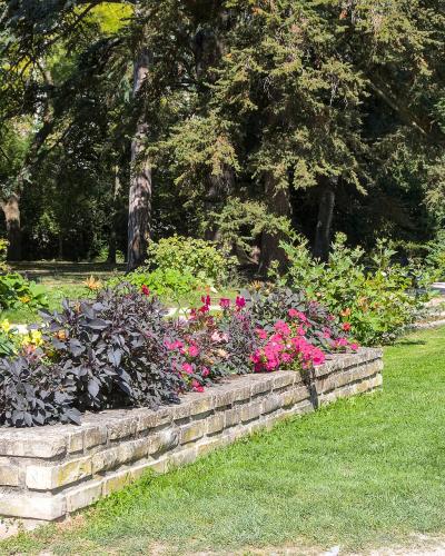 Flower bed by canal with classical pavilion in the background.